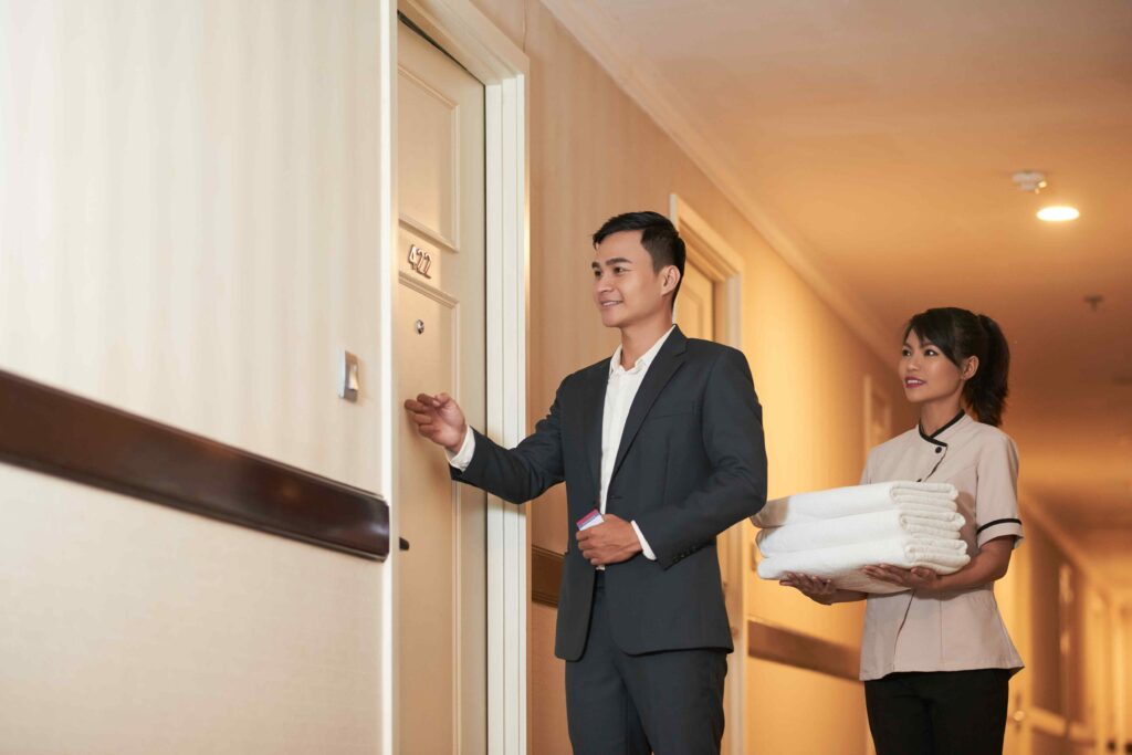 Director of housekeeping, accompanied by a housekeeper, knocking on the door of a suite.