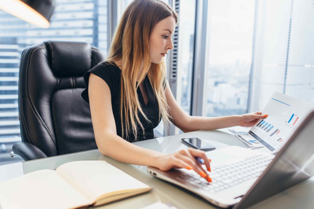 Person reviewing a report with a bar graph while seated at their computer.