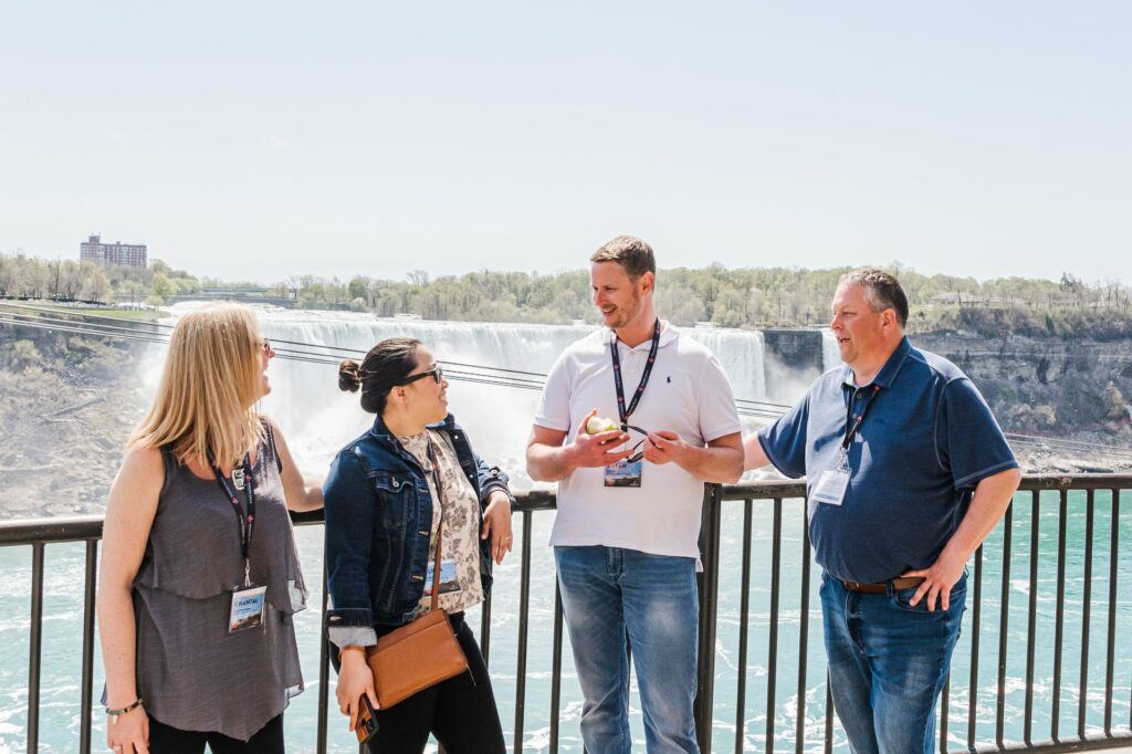 Un guide touristique donne de l'information à un petit groupe de gens au bord des chutes Niagara.