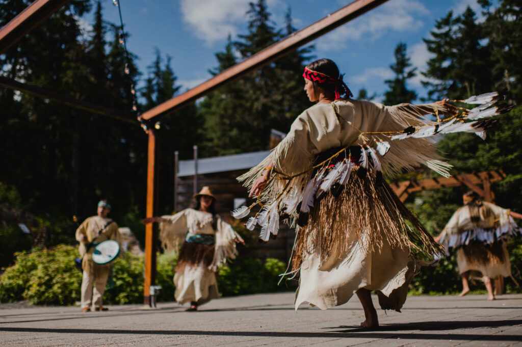 Des danseurs autochtones se produisent sur scène à l'extérieur du centre culturel Lil'wat de Squamish. 